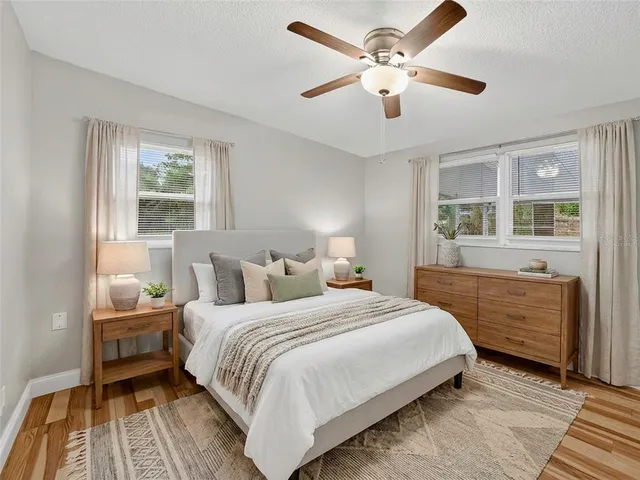 a bedroom with a large bed wooden floor and window