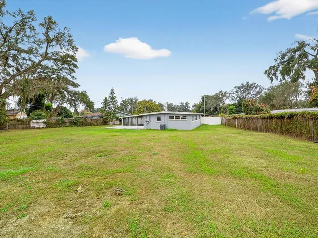 a view of yard with swimming pool and green space