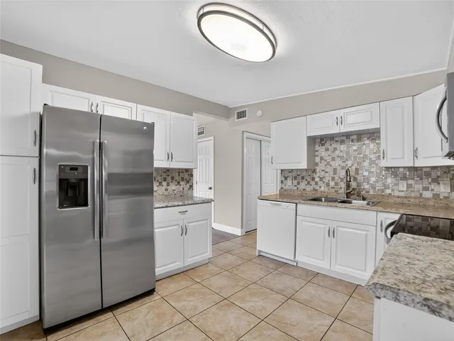 a kitchen with stainless steel appliances granite countertop a refrigerator and a sink