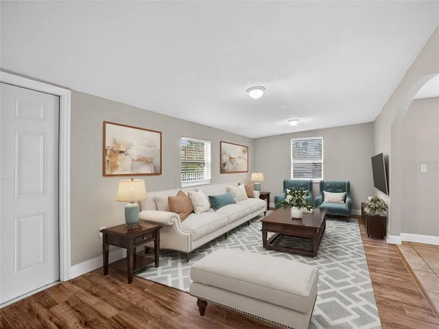 a living room with furniture and a wooden floor