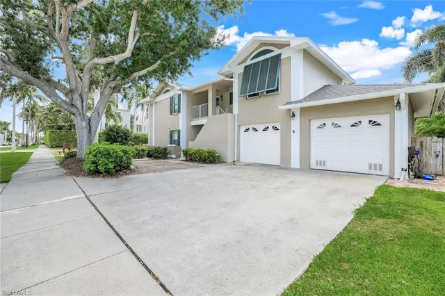 a view of a white house with a yard and plants