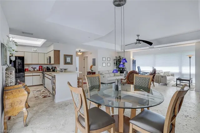 a dining room with kitchen island furniture a chandelier and kitchen view