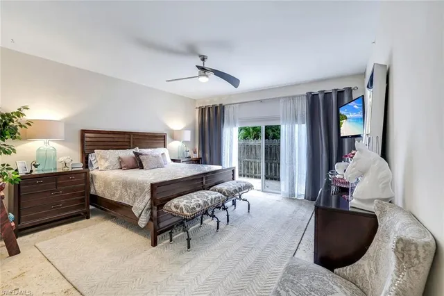 a bedroom with a bed large window and couch