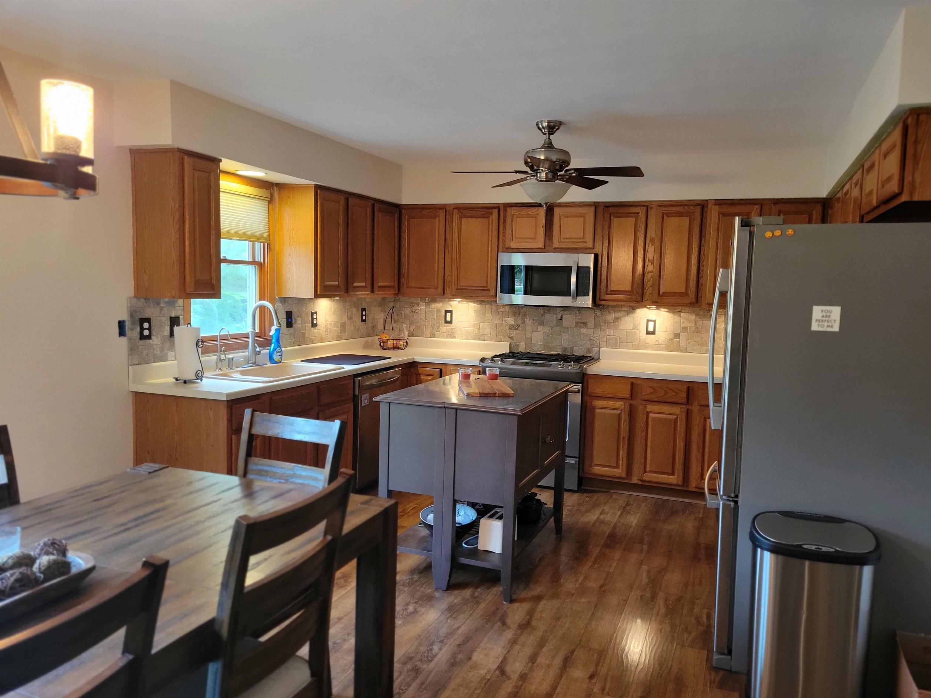 1126 Old Hunter Run Byron, IL 61010 - Photo 13 of 24 a kitchen with a dining table chairs and a refrigerator