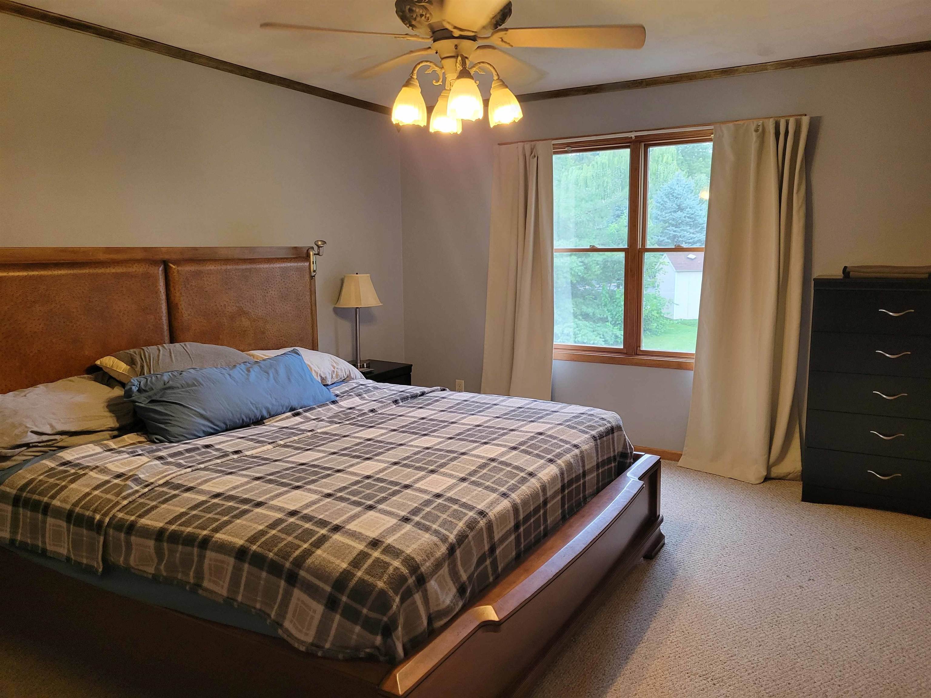 1126 Old Hunter Run Byron, IL 61010 - Photo 14 of 24 a bed sitting in a bedroom next to a window and a chandelier