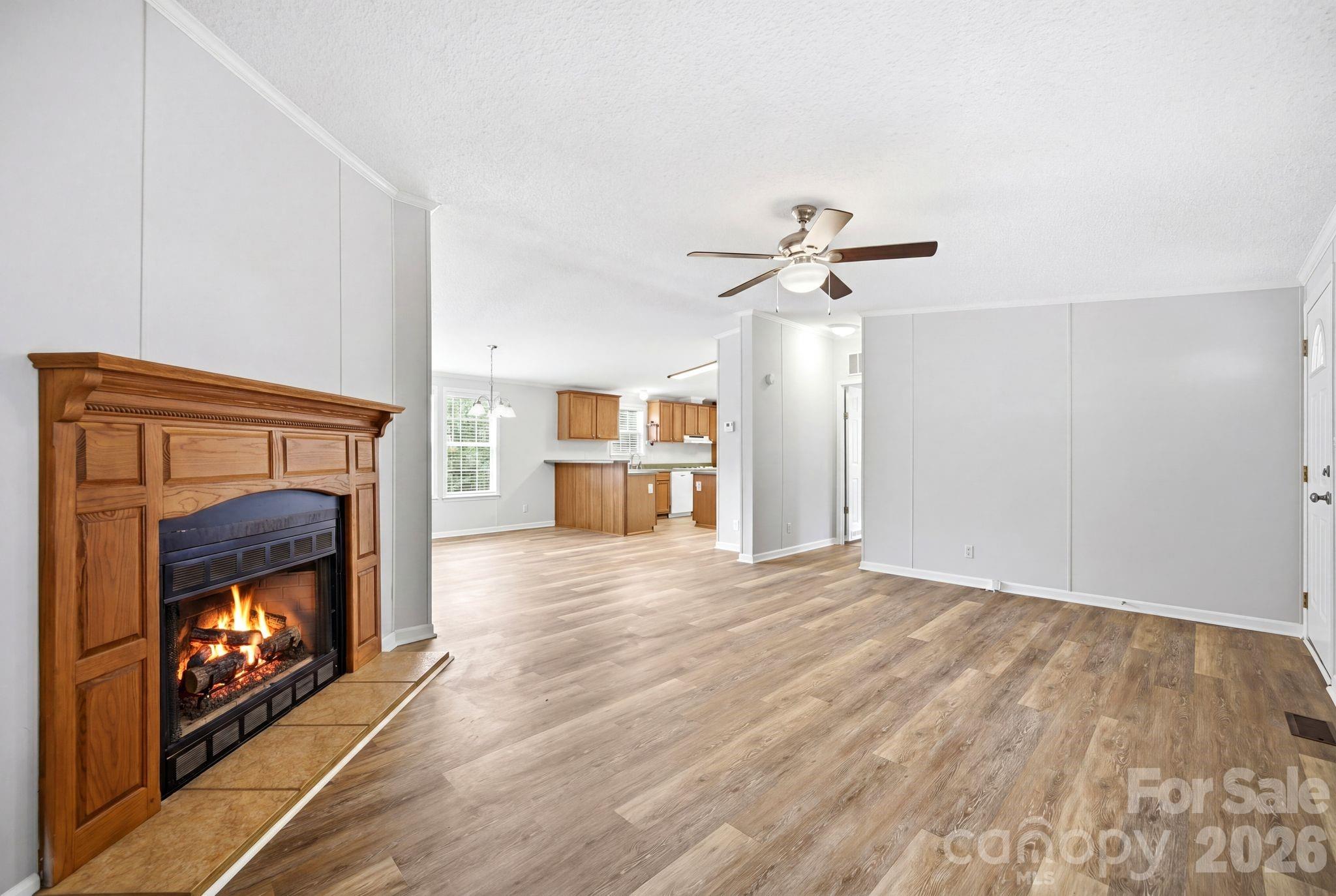 2368 Beth Haven Church Road Denver, NC 28037 - Photo 10 of 42 a view of an empty room with a fireplace and a ceiling fan