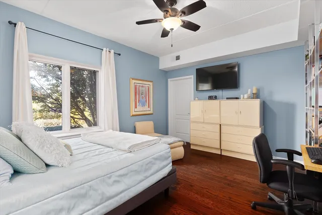 a bedroom with a bed a flat screen tv and a window