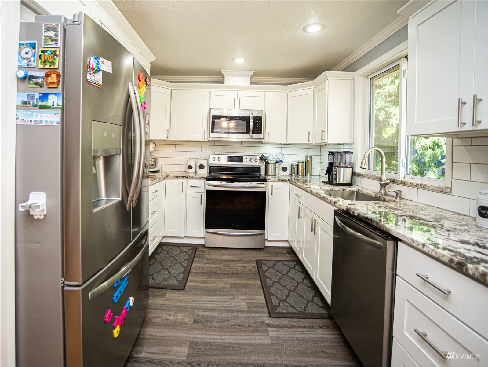24311 3rd Place West Bothell, WA 98021 - Photo 11 of 30 a kitchen with stainless steel appliances granite countertop a refrigerator a stove a sink and dishwasher with wooden floor