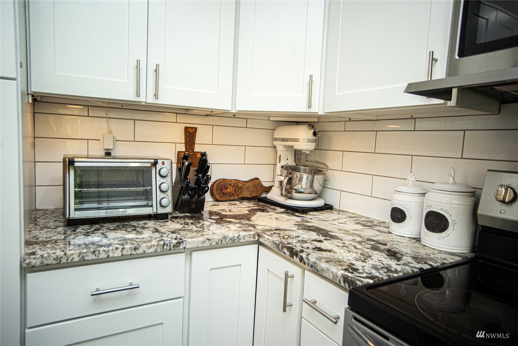 24311 3rd Place West Bothell, WA 98021 - Photo 13 of 30 a kitchen with granite countertop white cabinets and appliances