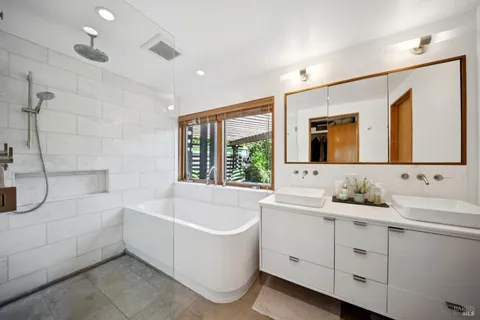 a bathroom with a bathtub a sink and a mirror