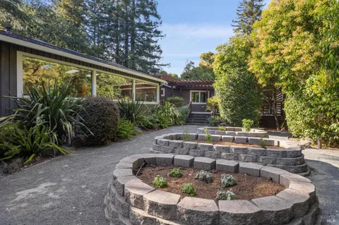 a view of a house with pool fire pit and chairs
