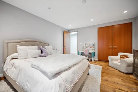 a bedroom with a bed and wooden floor