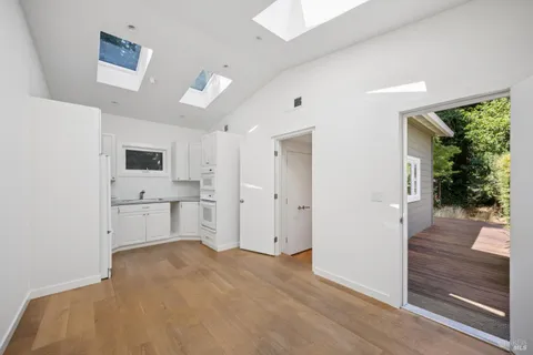 a view of a kitchen with a sink and dishwasher a refrigerator with white cabinets