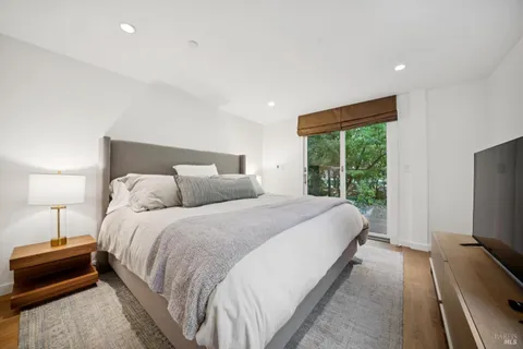 a large bedroom with a bed and a flat tv screen on the dresser