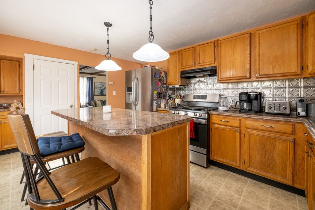 324 Stafford Road Fall River, MA 02721 - Photo 15 of 41 a kitchen with stainless steel appliances granite countertop wooden cabinets a dining table and chairs