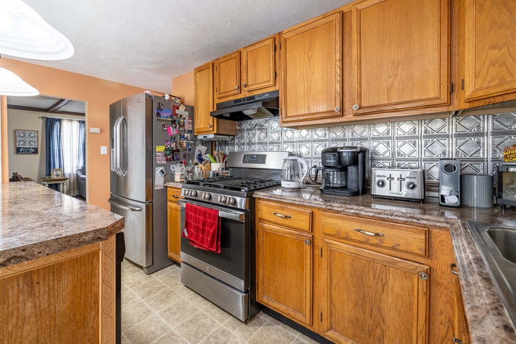 324 Stafford Road Fall River, MA 02721 - Photo 18 of 41 a kitchen with stainless steel appliances granite countertop a refrigerator a stove and a sink with cabinets