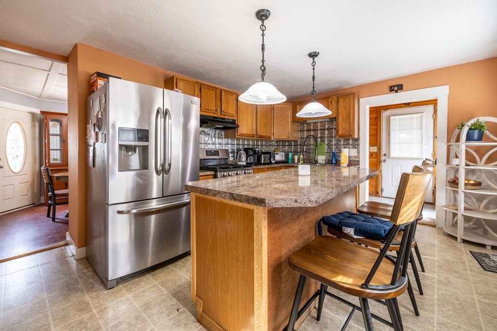 324 Stafford Road Fall River, MA 02721 - Photo 22 of 41 a kitchen with stainless steel appliances granite countertop a refrigerator a oven a sink a dining table and chairs with wooden floor