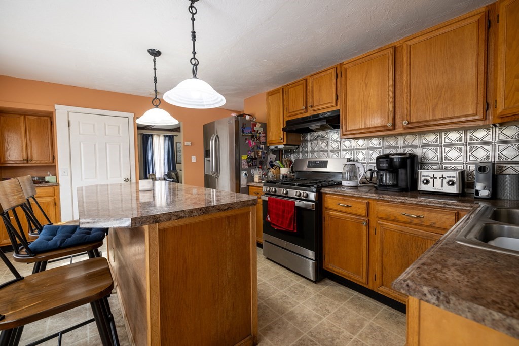 324 Stafford Road Fall River, MA 02721 - Photo 27 of 41 a kitchen with stainless steel appliances granite countertop a stove top oven a sink dishwasher and cabinets with wooden floor