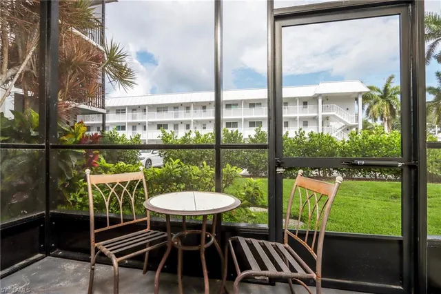 a view of a chairs and table in patio with a yard
