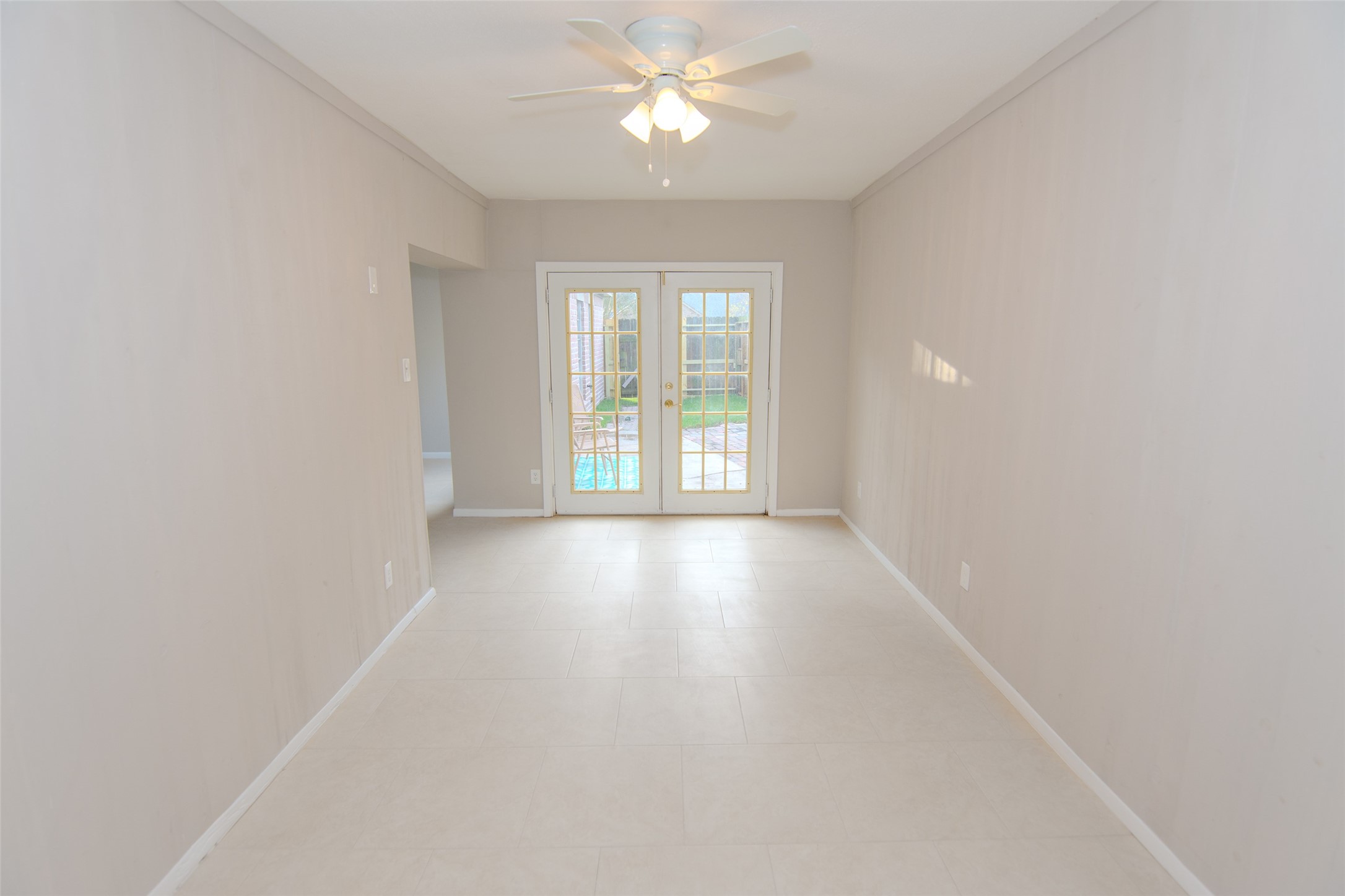 6703 Stonewater Houston, TX 77084 - Photo 15 of 30 Game room/ home office with neutral walls and tiled flooring, featuring a ceiling fan and French doors leading to an outdoor space.