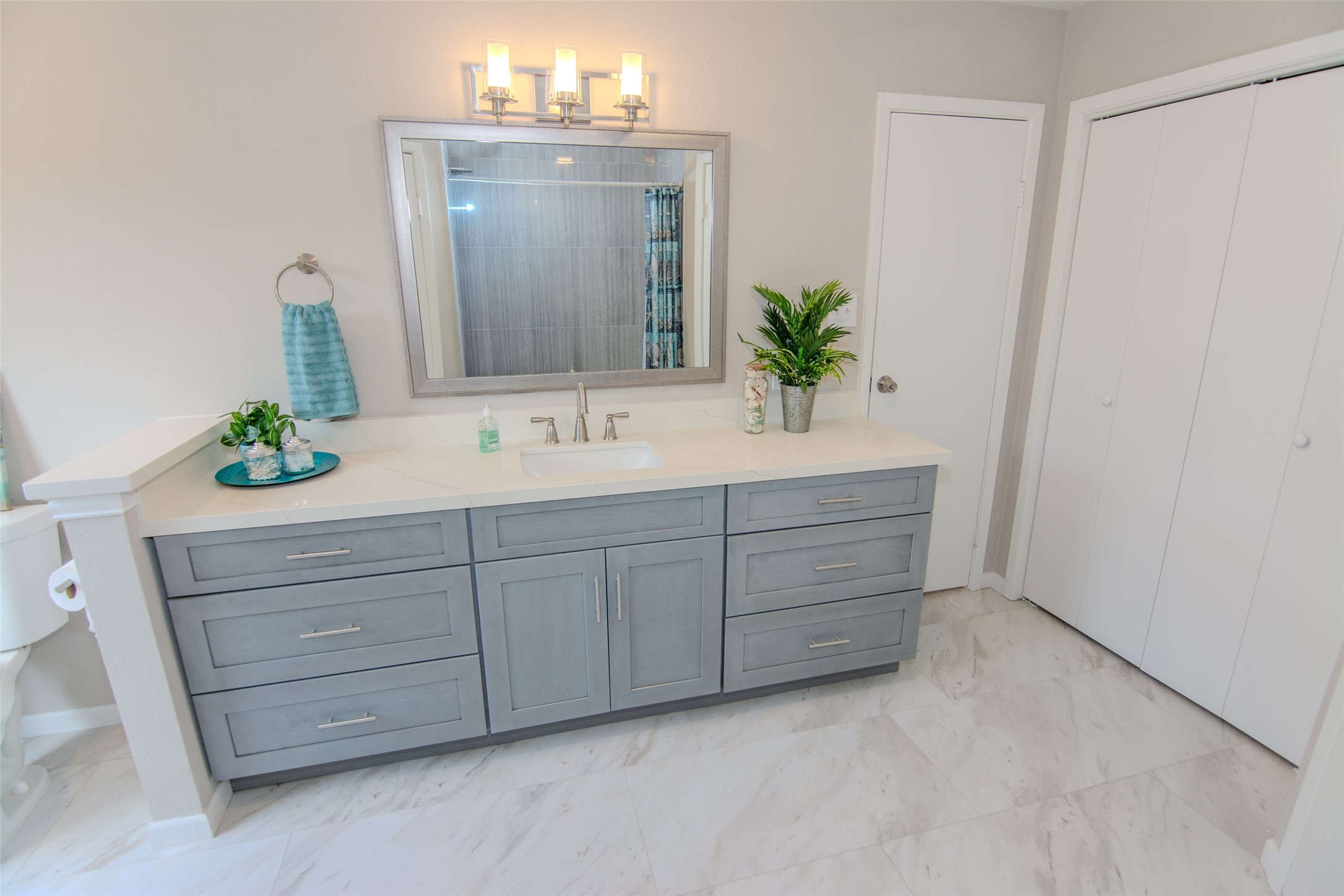6703 Stonewater Houston, TX 77084 - Photo 18 of 30 Primary bathroom features a modern design with a light gray vanity and ample storage. It has a sleek countertop, a large mirror with stylish lighting, and attractive tile flooring. His & Her closets.