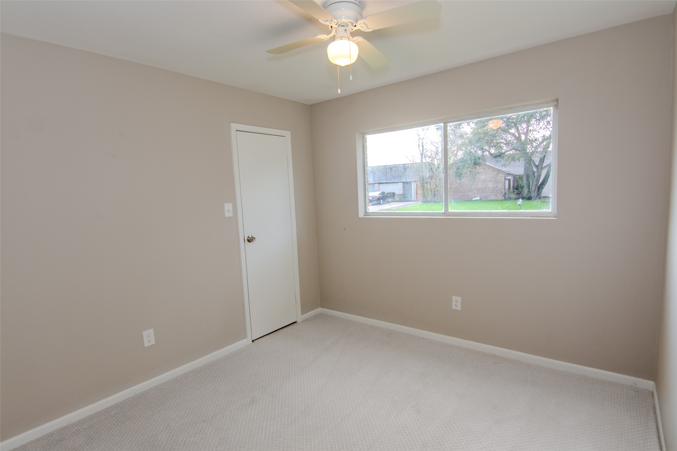 6703 Stonewater Houston, TX 77084 - Photo 21 of 30 Bedroom 3 carpeted room with neutral walls. It features a ceiling fan with a light, a single window allowing natural light.
