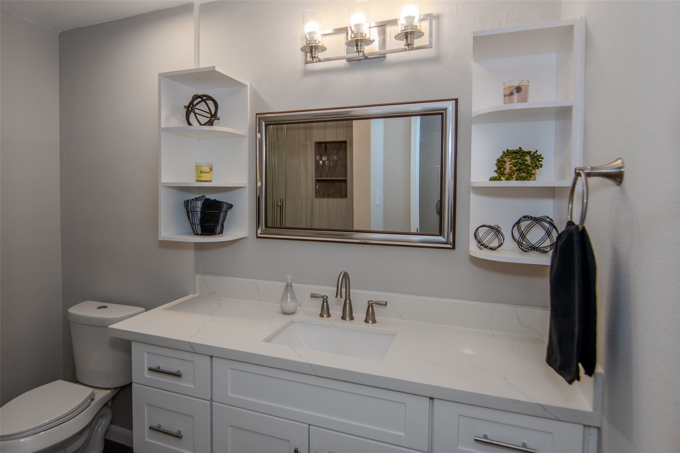 6703 Stonewater Houston, TX 77084 - Photo 22 of 33 The guest bathroom features an expansive vanity area offering ample storage. Designer shelving adds an elegant touch to the space.