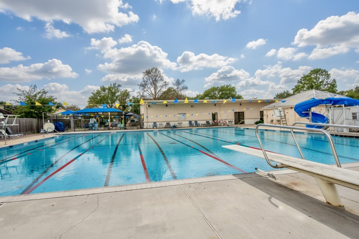 6703 Stonewater Houston, TX 77084 - Photo 29 of 33 Stonecreek is looking for swimmers for the Stonecreek Singrays. With its Olympic size swimming pool includes with a diving board and water slide. It features clear blue water, lane markings, and is surrounded by a spacious deck area with seating. The pool area is ideal for relaxation and recreation, providing a perfect spot for family and friends.