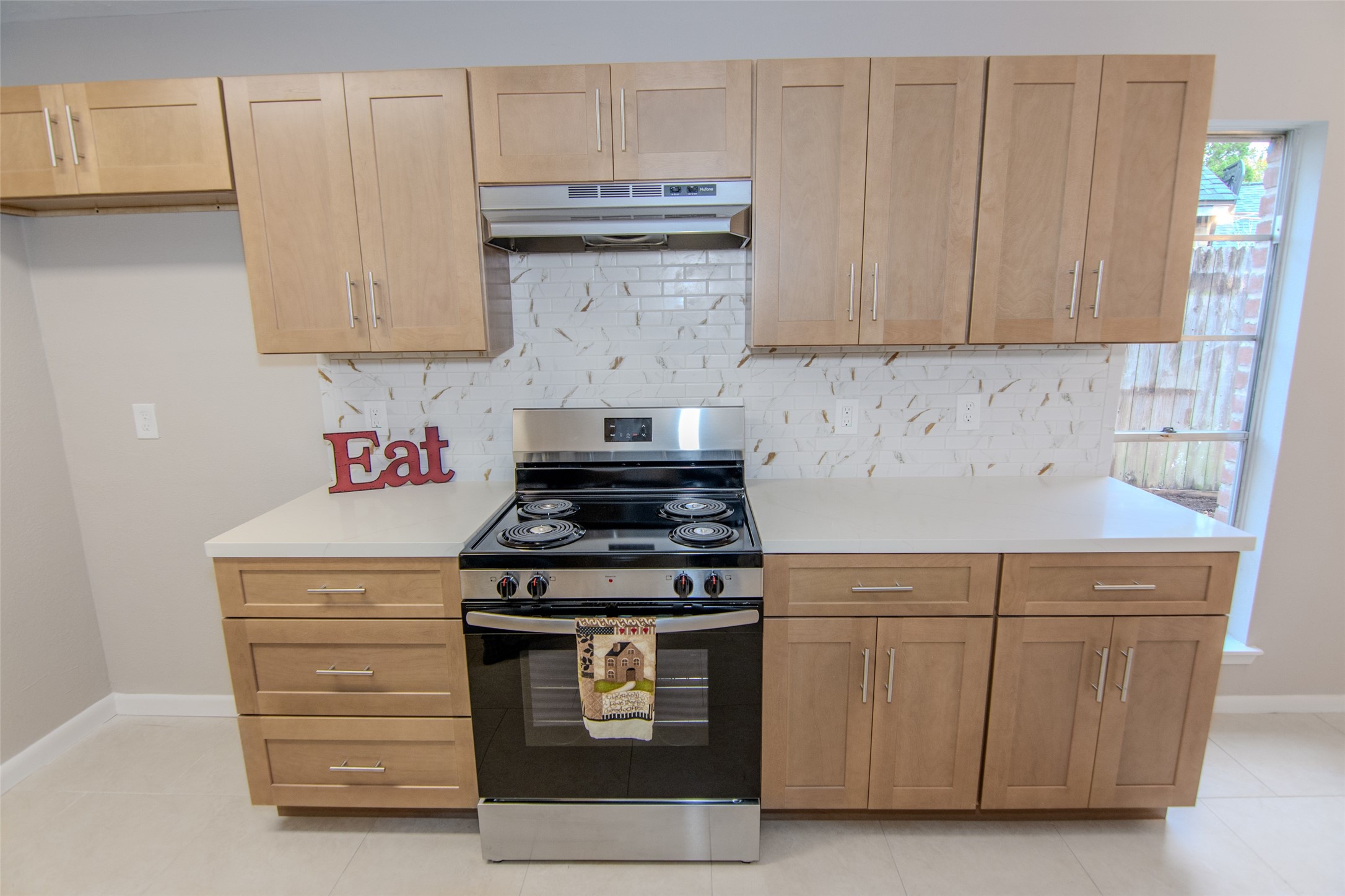 6703 Stonewater Houston, TX 77084 - Photo 7 of 30 Stainless stove with vent a hood and a stylish white designer backsplash that complement the cabinetry.