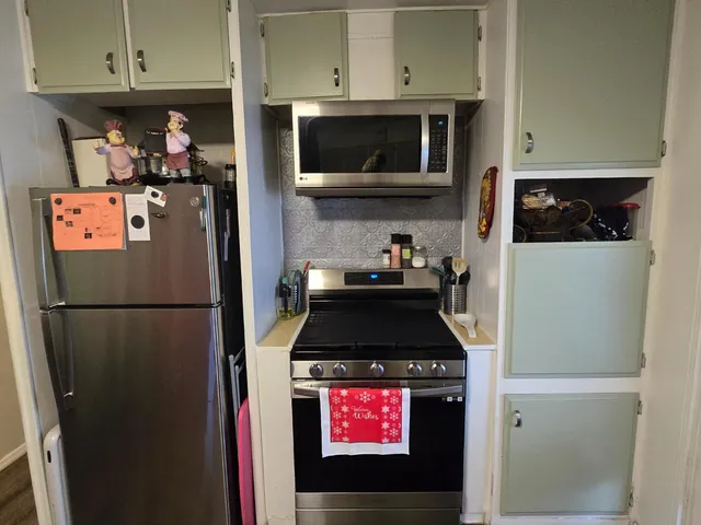 a kitchen with stainless steel appliances a refrigerator a stove top oven and cabinets