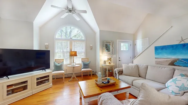 a living room with furniture a flat screen tv and a large window