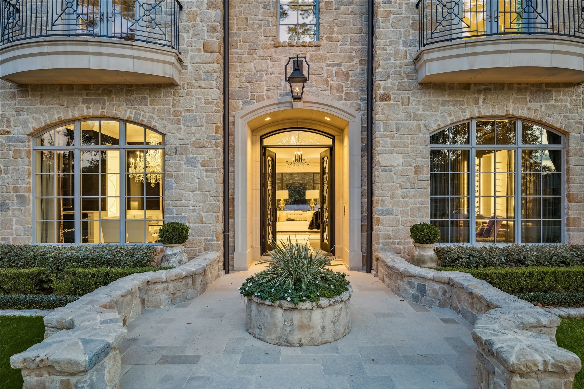 220 Merrie Way Lane Houston, TX 77024 - Photo 2 of 50 Soft tumbled stone and thoughtfully placed uplighting shape a warm, inviting façade, offering a first glimpse of the home’s timeless symmetry and refined curb appeal.
