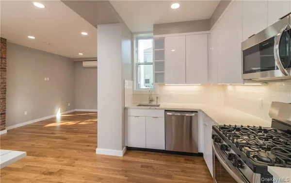 a kitchen with stainless steel appliances kitchen island granite countertop a stove and a sink