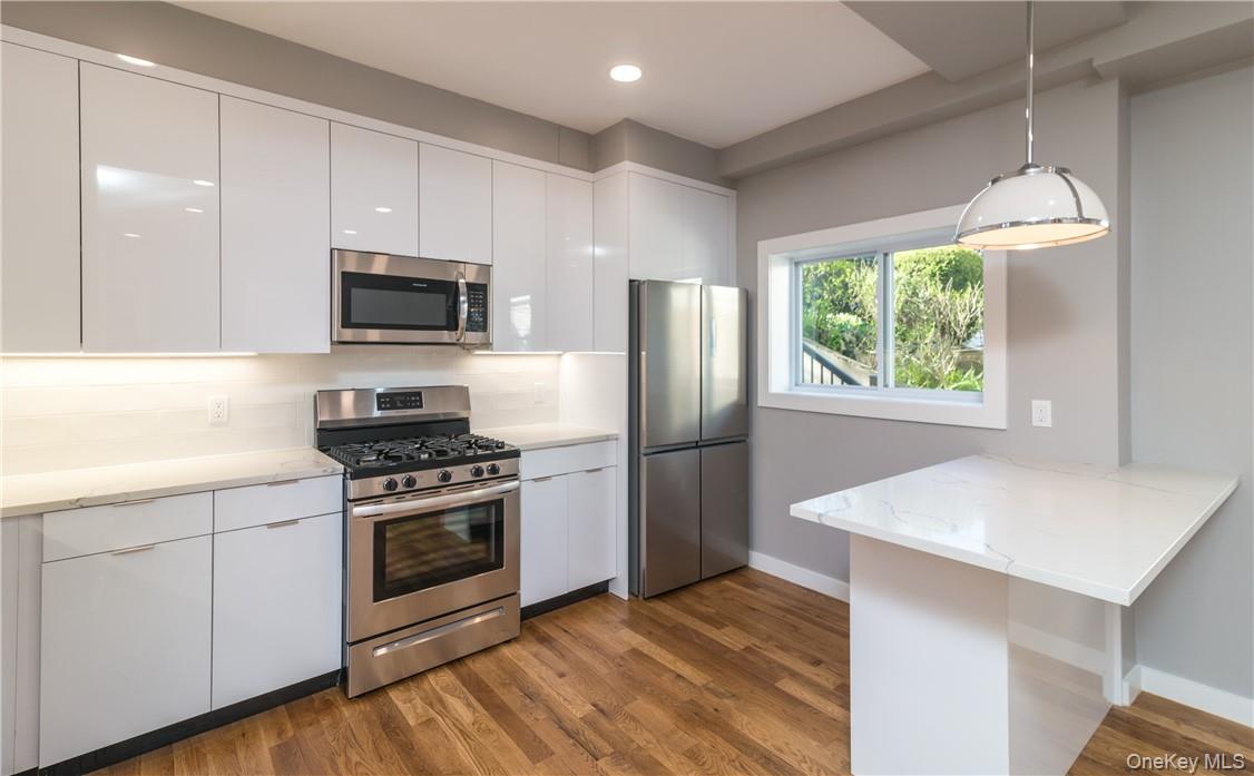86 Main Street, Unit 3 Dobbs Ferry, NY 10522 - Photo 7 of 24 a kitchen with a stove a sink and a microwave