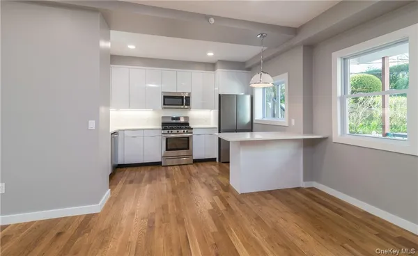 a kitchen with wooden floors and stainless steel appliances