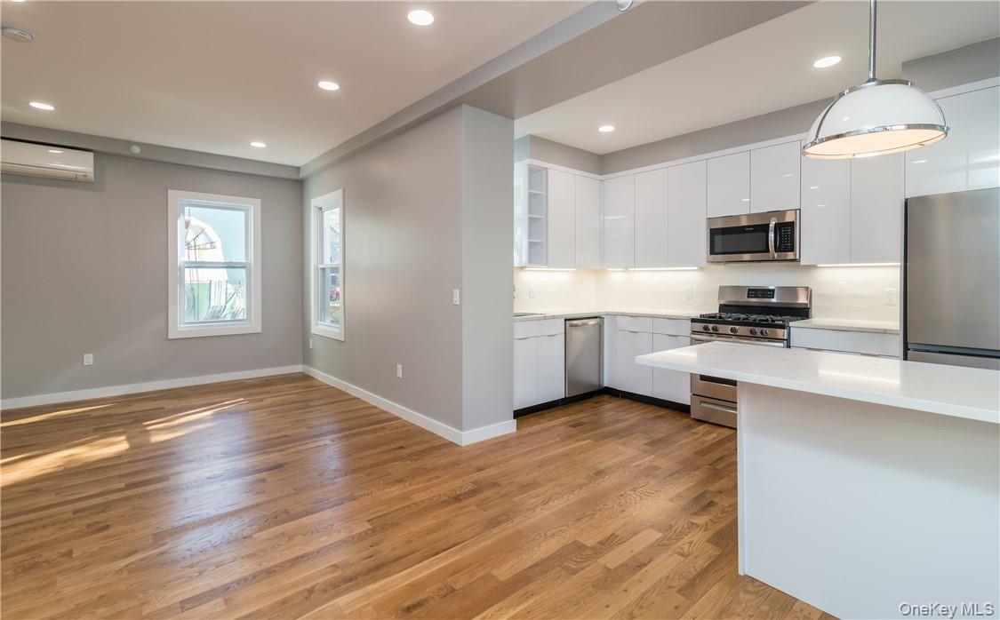 86 Main Street, Unit 3 Dobbs Ferry, NY 10522 - Photo 9 of 24 a kitchen with kitchen island white cabinets and stainless steel appliances