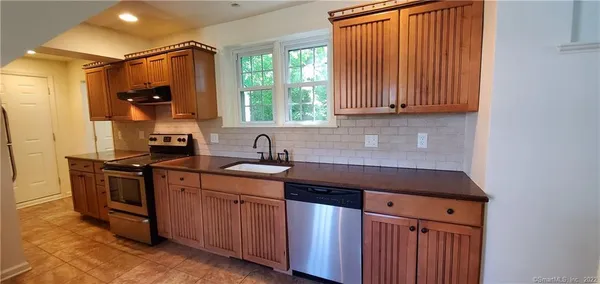 a kitchen with stainless steel appliances granite countertop a sink a stove and a refrigerator