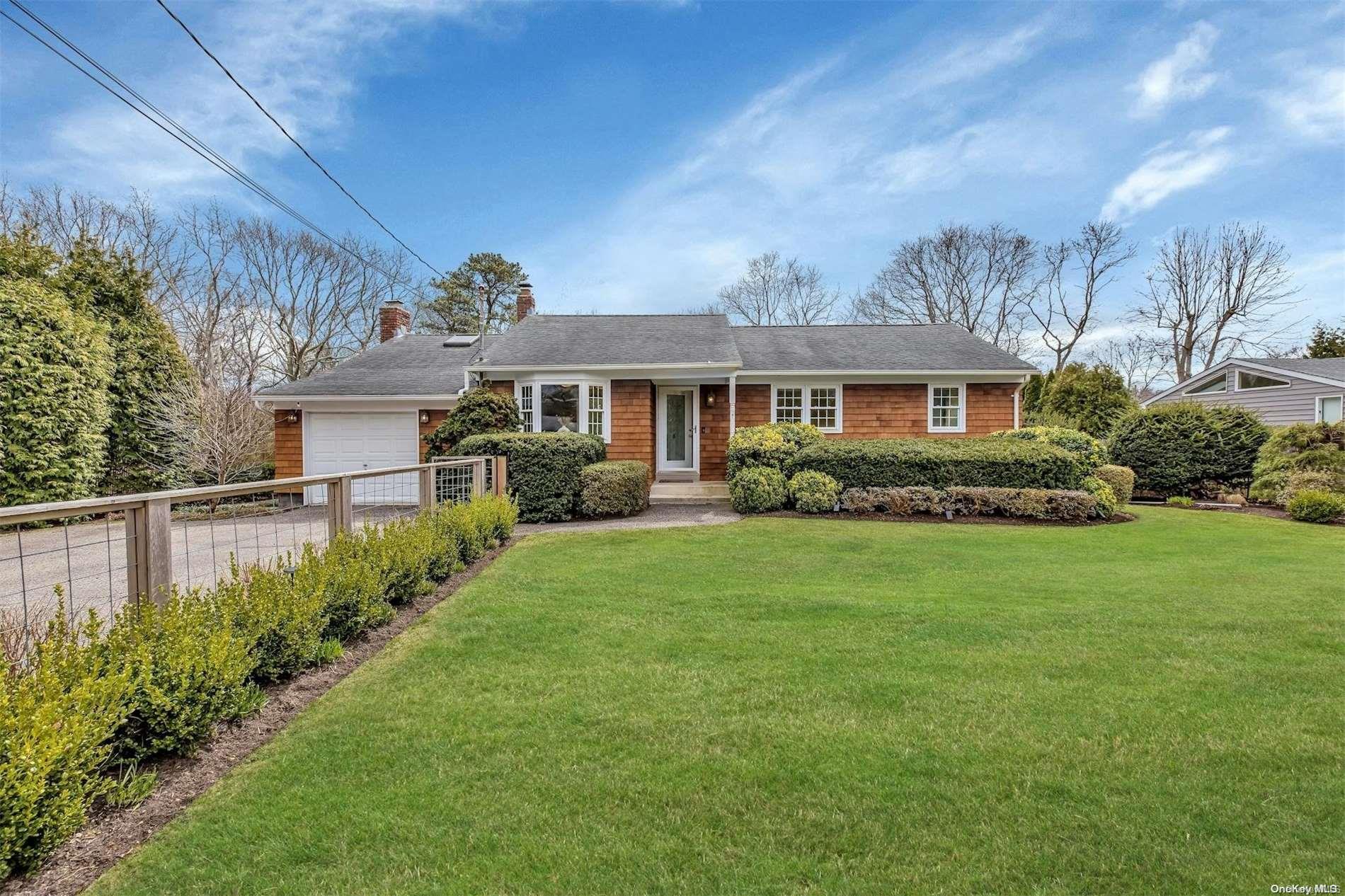 8 Lovell Road Hampton Bays, NY 11946 - Photo 1 of 1 a front view of a house with a garden and plants