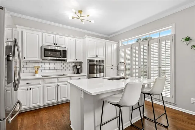 a kitchen with granite countertop a stove a sink and a refrigerator