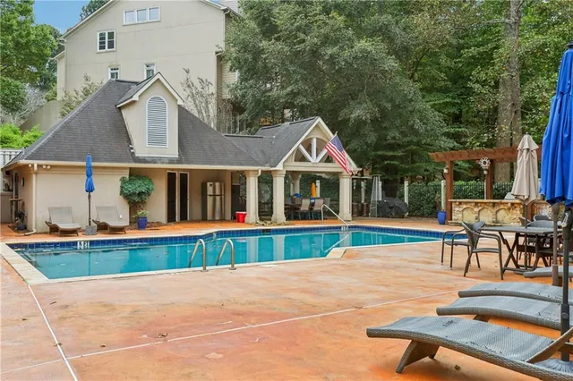 a view of a house with a yard and large tree