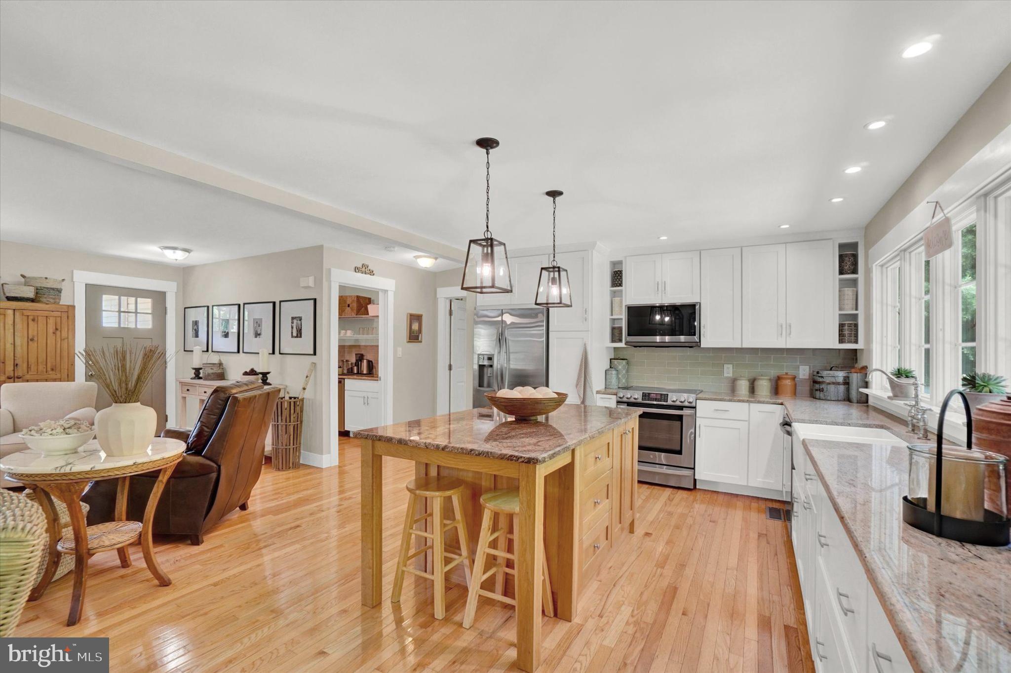 669 Woodburne Road Lewisberry, PA 17339 - Photo 9 of 44 a kitchen with stainless steel appliances granite countertop a stove top oven a sink dishwasher a dining table and chairs with wooden floor