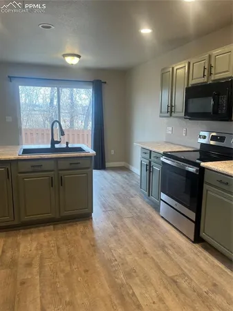 a kitchen with stainless steel appliances granite countertop a stove a sink and a microwave