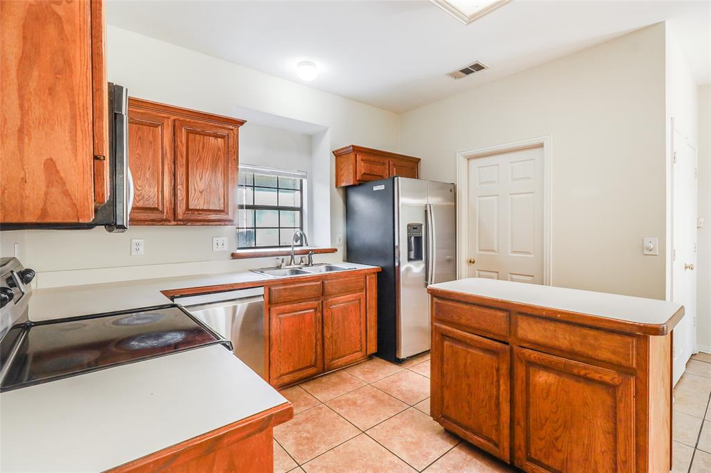 8100 Steamers Lane Frisco, TX 75035 - Photo 7 of 24 a kitchen with stainless steel appliances granite countertop a sink stove and cabinets