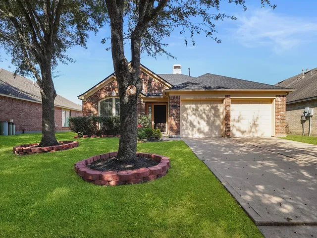 a front view of a house with a yard tree and outdoor seating