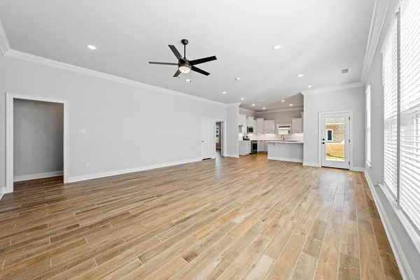a view of empty room with wooden floor and window