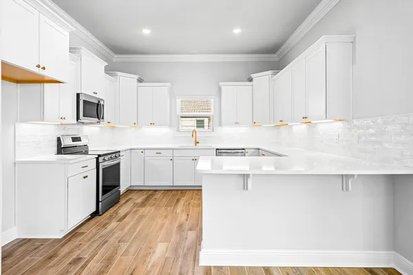 a kitchen with kitchen island granite countertop a sink appliances cabinets and a counter top space