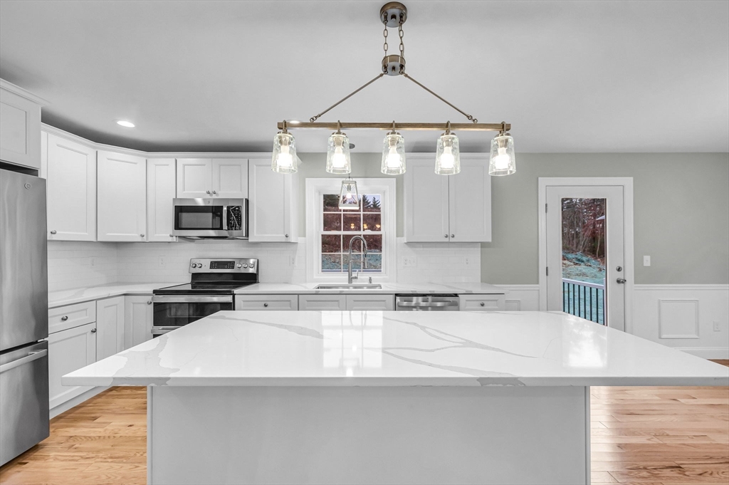 6 High Blf Road Belchertown, MA 01007 - Photo 16 of 42 a kitchen with stainless steel appliances a stove a sink a refrigerator white cabinets and wooden floor