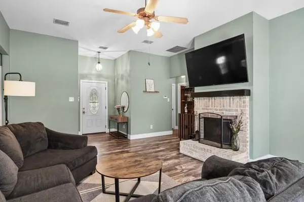 a living room with furniture a flat screen tv and a fireplace