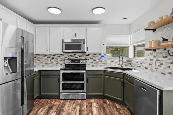 a kitchen with stainless steel appliances a stove sink microwave and refrigerator