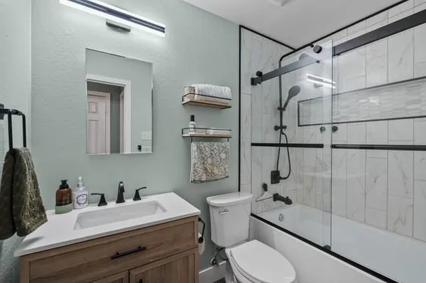 a bathroom with a sink a toilet and shower